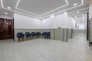 a meeting room with blue chairs in a lobby at Hotel Elite Clark in Noida
