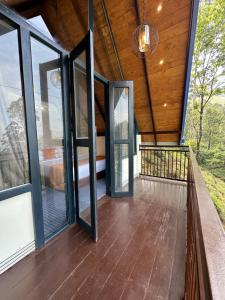 an empty porch with glass doors and a chandelier at Bluefield Cabana in Ramboda