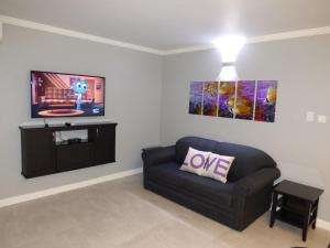 Una sala de estar con un sofá y un televisor de pantalla plana. en Beach One Bedroom Suite C5, en Ocho Ríos