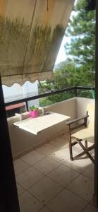 a bench on a balcony with a table and a chair at 1st floor studio in Kalathas in Kalathas