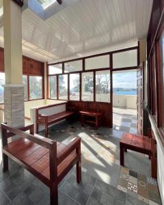 a room with benches and windows in a building at Caesarea Guesthouse in Berastagi