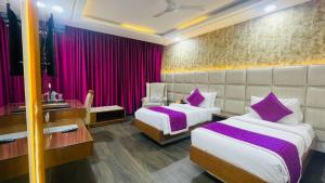 two beds in a hotel room with purple pillows at HOTEL JD HEAVENS in Jhajjar +40 photos
