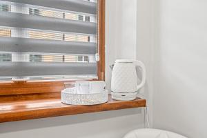 a coffee maker sitting on a shelf next to a window at Central Platinum Apartments 1 in Rybnik +9 photos