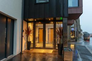 a building with glass doors on a city street at Albert Hotel in Kirkwall