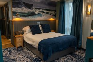 a bedroom with a bed with a painting on the wall at Albert Hotel in Kirkwall +11 photos