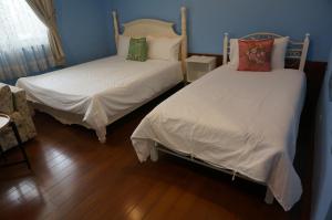 2 camas en una habitación con paredes azules en Dong Hua Dream House, en Pinghe