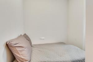 a bed in a white room with a pillow at Central Platinum Apartments 7 in Rybnik