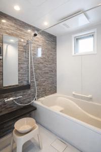 a bathroom with a tub and a stool and a sink at Dual Life House Koza in Okinawa City +55 photos
