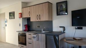 a kitchen with wooden cabinets and a sink and a table at Gîte du Coupiat in Walcourt +26 photos