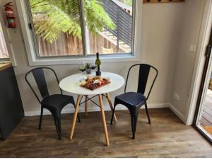 a table with three chairs and a bottle of wine at Noojee views - cozy studio in Noojee +43 photos