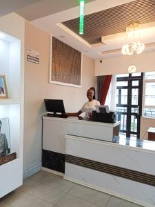 a woman standing at a cash register in a store at Saimo Hotel-Kabarnet in Kabarnet