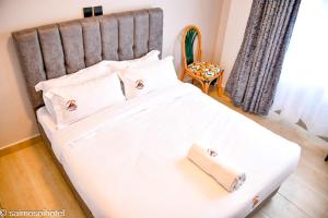 a bed with white sheets and pillows in a bedroom at Saimo Hotel-Kabarnet in Kabarnet