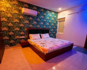 a bedroom with a bed with a floral wall at Hotel Meera in Bāwal +3 photos