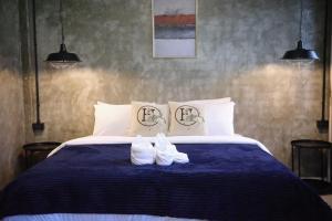 a bedroom with a bed with two white shoes on it at Dvilla in Ban Bang Saen (1)