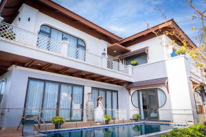 a woman standing on the balcony of a house at B'Villa Luxury in Dong Hoi
