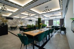 a dining room with a long table and green chairs at Stara Kuźnia in Łuków