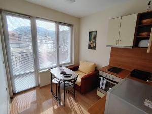 a small living room with a table and a kitchen at Studio apartment with mountain view at Eagle Rock complex in Beli Iskar