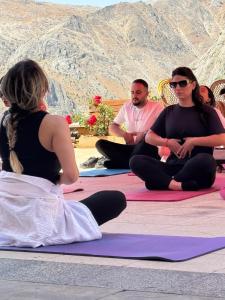 a group of people sitting on mats in front of a mountain at Serge Otel in Arapkir