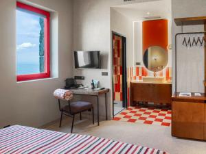 a bedroom with a desk and a sink and a mirror at Hotel Boutique Faro Silleiro in Baiona +56 photos