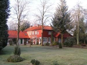 une grande maison rouge avec un toit rouge dans l'établissement Gästehaus Heidehof, à Soltau