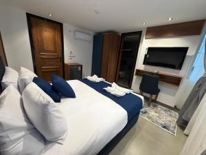 a bedroom with a large bed with blue pillows and a television at The Grand Delta Hotel in Cairo