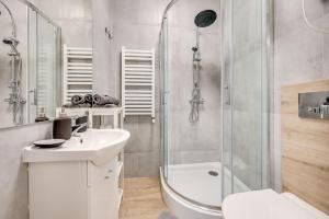 a white bathroom with a shower and a sink at Central Platinum Apartments 25 Studio z aneksem kuchennym i tarasem in Rybnik +14 photos