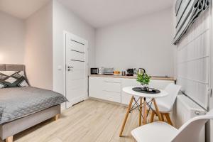 a small bedroom with a bed and a small table at Central Platinum Apartments 25 Studio z aneksem kuchennym i tarasem in Rybnik
