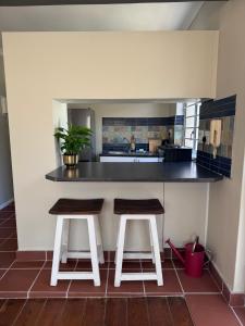 a kitchen with two stools and a counter top at Outspan Lodge in Fish Hoek +14 photos