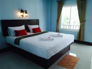a bedroom with a large white bed with red pillows at Zam Zam House in Ko Lanta