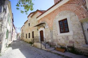 an alley in an old stone building with a window at Atrium Suites Taş Konak in Urla