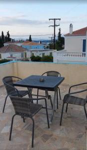 a picnic table and two chairs on a patio at Pension Panagiota in Spetses