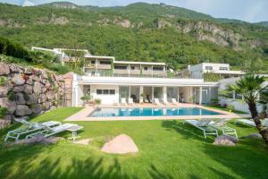 a villa with a swimming pool and a house at Hidalgo Suites in Merano