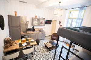 a small living room with a table and a kitchen at Charming studio with sofa, bed and terrace-AS in Carcassonne +11 photos