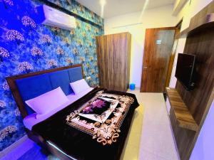 a bedroom with a bed with a blue wall at Hotel Meera in Bāwal