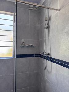 a shower with a glass door in a bathroom at Outspan Lodge in Fish Hoek