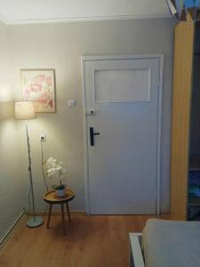 a room with a door and a table with a lamp at Chillroom in Rąbień