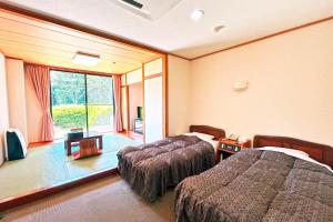 a hotel room with two beds and a window at Greenpia Yame in Yame