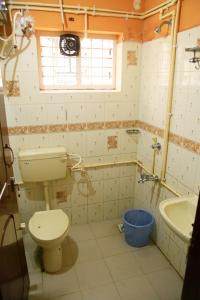 a bathroom with a toilet and a tub and a sink at Avalan Resort Homestay in Thekkady