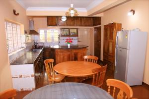 a kitchen with a table and a refrigerator at Avalan Resort Homestay in Thekkady