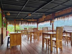 a restaurant with wooden tables and chairs in a room at Bukit Luah Sidemen in Sidemen