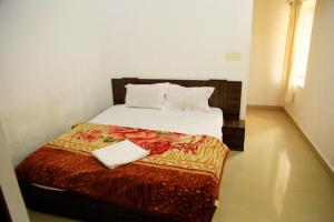 a bedroom with a bed with a book on it at Avalan Resort Homestay in Thekkady +17 photos