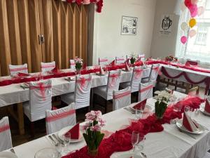 a room with white tables with red flowers on them at Hotel Habsburg in České Hamry +48 photos