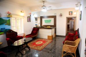 a living room with red chairs and a counter at Avalan Resort Homestay in Thekkady