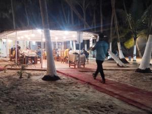 a person walking on the beach at night at Samant Beach Resort in Malvan
