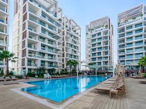 a large swimming pool with two tall buildings at Luxury garden suite with pool view in Eilat