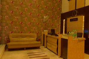 a room with a desk and a chair and a wall at Hotel Metro in Kumbakonam