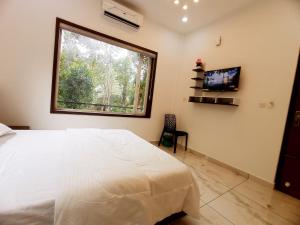 a bedroom with a large white bed and a window at Chikkary's Inn in Munnar +44 photos