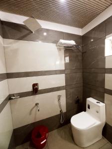 a bathroom with a white toilet in a room at Chikkary's Inn in Munnar