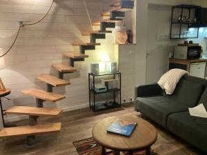 a living room with a couch and a staircase at Portec la mer et le sentier côtier à pied in Moëlan-sur-Mer
