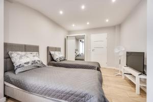 a bedroom with two beds and a flat screen tv at Central Platinum Apartments 30 Studio z aneksem kuchennym in Rybnik